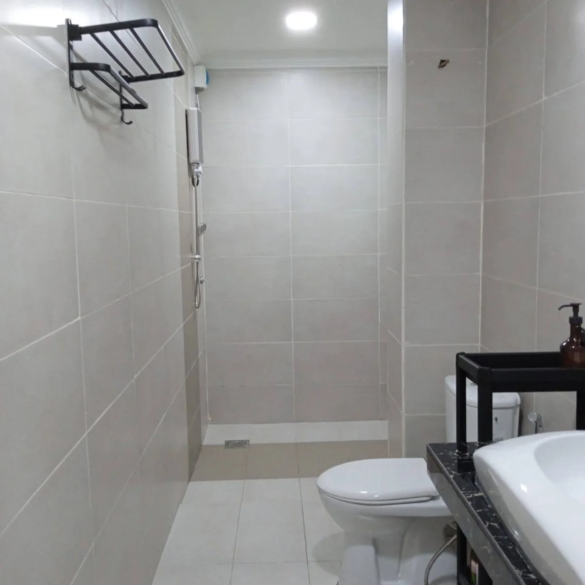 Tiled bathroom with a shower, toilet and washbasin at Paradise Lodge