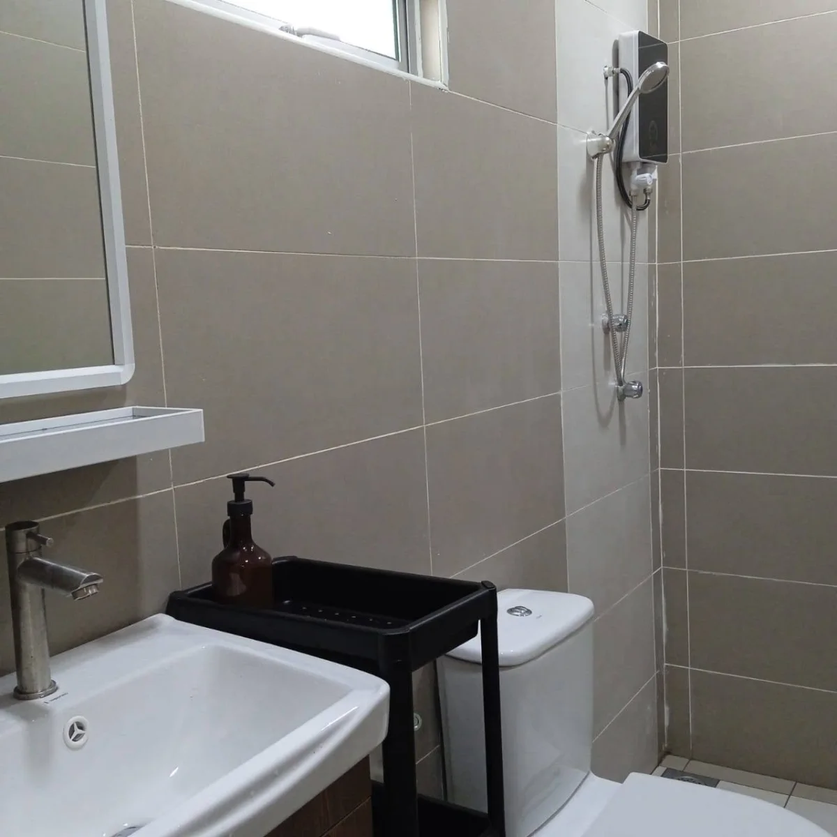 Bathroom washbasin, mirror and wall-mounted shower at Paradise Lodge