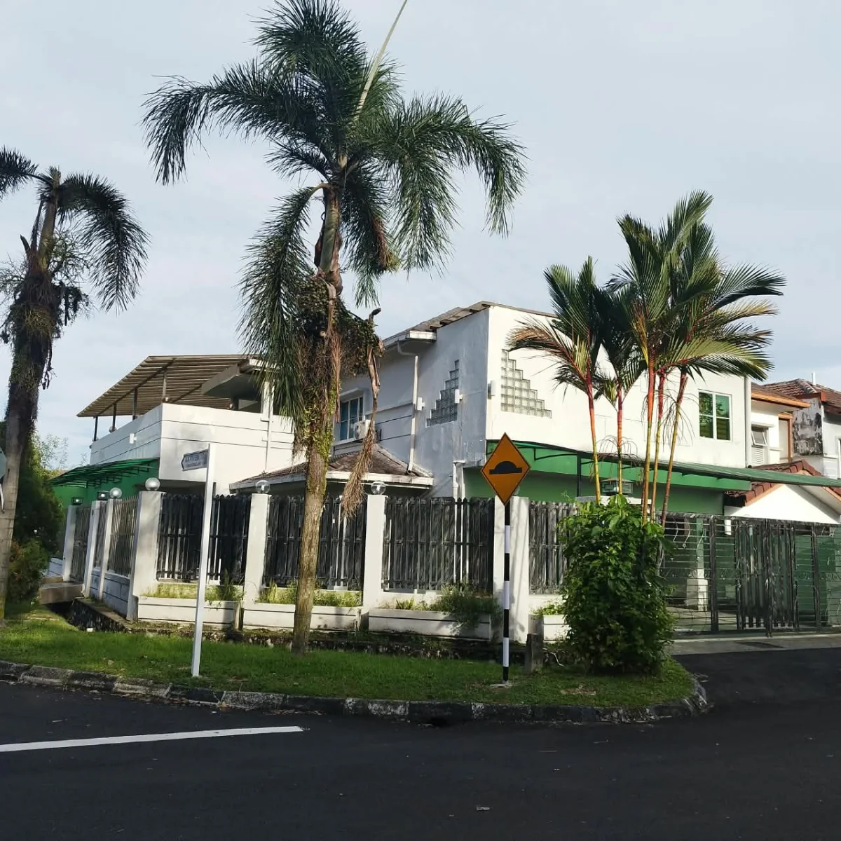 Paradise Lodge exterior in Putra Heights with palms, a green awning and gated frontage