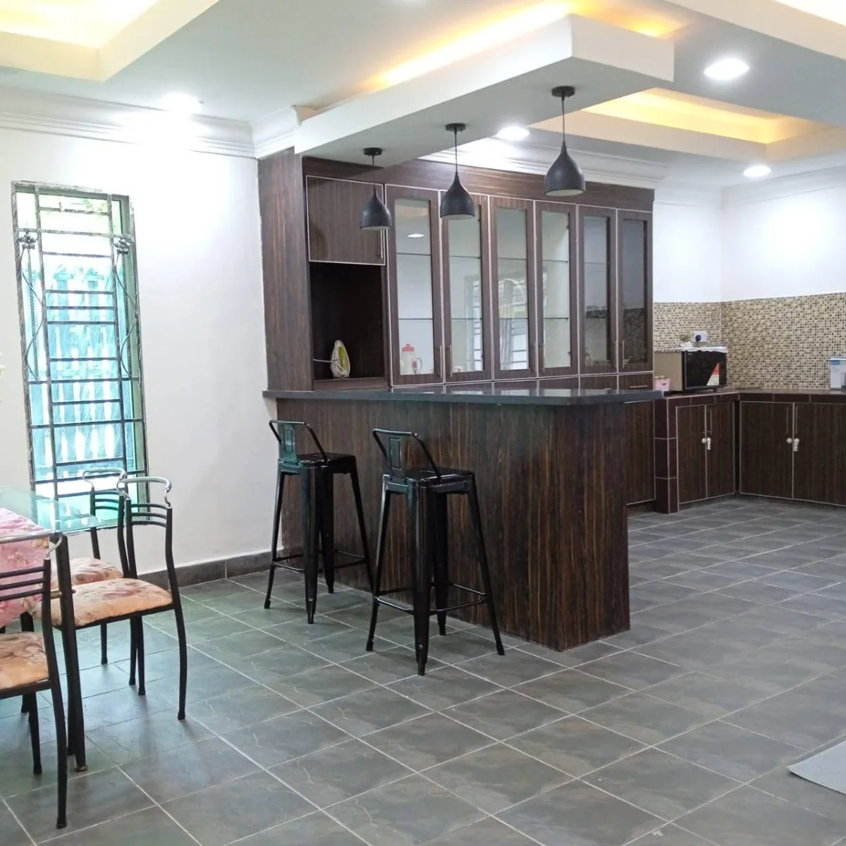 Wooden kitchen cabinets and counter beside the dining space at Paradise Lodge