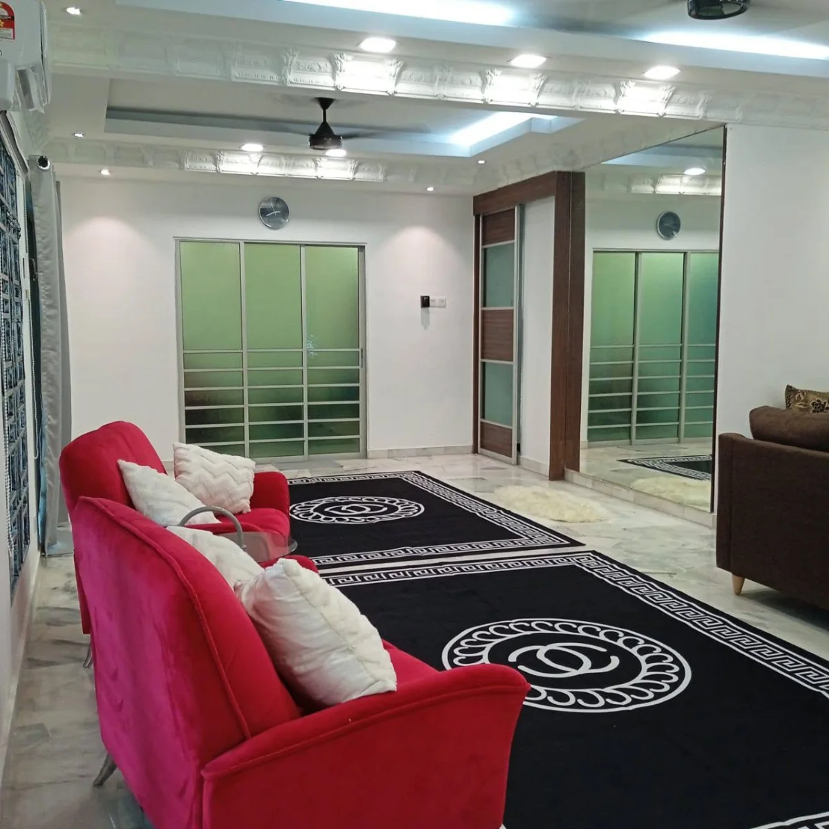 Red sofa, patterned rugs and sliding doors in the lounge at Paradise Lodge