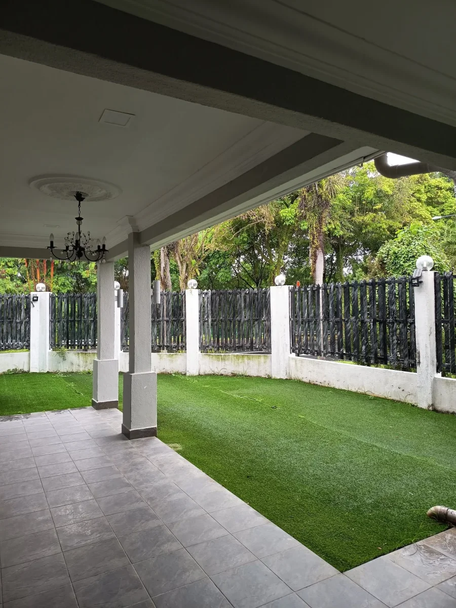 Sheltered veranda overlooking the lawn and palms at Paradise Lodge