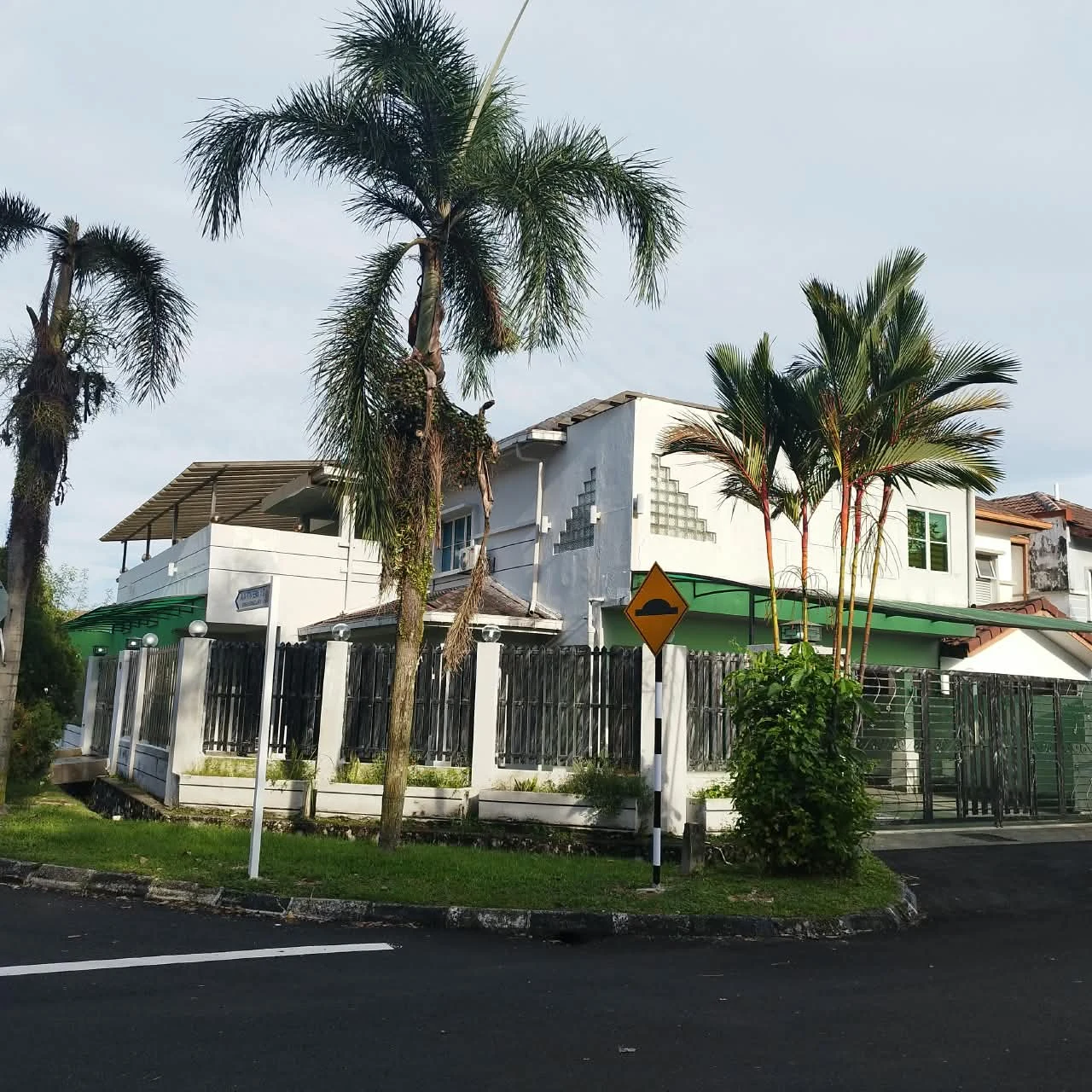 Paradise Lodge nursing home exterior, with palms, a green awning and gated street frontage